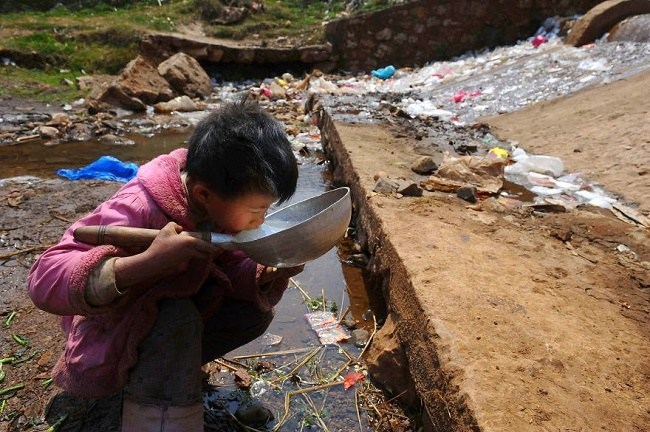 Kid drinking from a sewer line